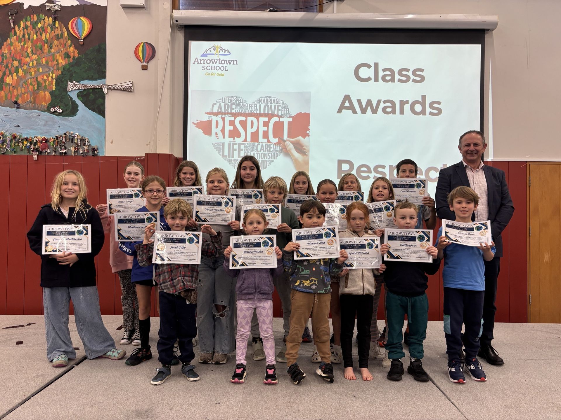 Students holding certificates at class awards with the principal
